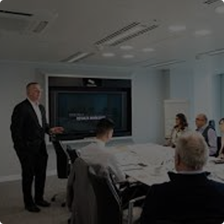 Steve Mills leading a private coaching session with business owners in a boardroom setting